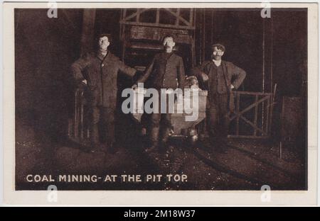 Mines de charbon - au sommet de la fosse : photo de trois mineurs de charbon debout à côté de l'ascenseur de la fosse, ils sont pendu contre un wagon rempli de charbon. L'image est l'une des photos publiées sous forme de cartes postales par M. Brookes de Pontypridd, au sud du pays de Galles Banque D'Images