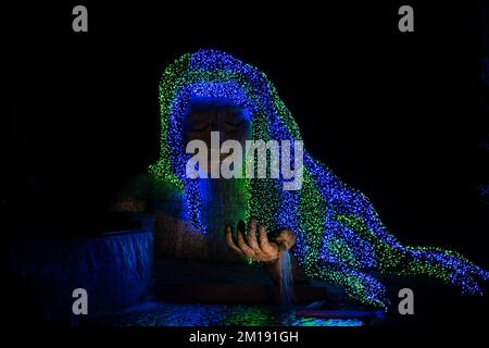 Une belle statue de mère nature avec ses cheveux illuminés par des lumières de Noël Banque D'Images