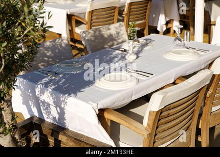 Street café en été avec des chaises et des tables en bois vintage sur une rue touristique. Restaurant ou café vide sans visiteurs. Photo de haute qualité Banque D'Images