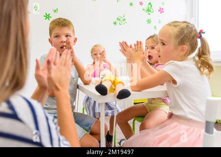 Séance d'ergothérapie pour enfants. Groupe d'enfants faisant des exercices ludiques avec leur thérapeute. Banque D'Images