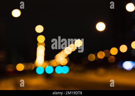 Lumières de rue floues la nuit, photo d'arrière-plan abstraite non focalisée avec effet de bokeh optique Banque D'Images