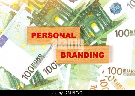 Concept d'entreprise. Sur fond de factures en euros, le texte est écrit sur des blocs de bois - marque personnelle Banque D'Images