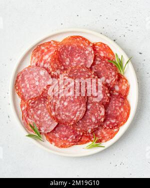 Saucisse de salami finement tranché sur une assiette, vue de dessus Banque D'Images