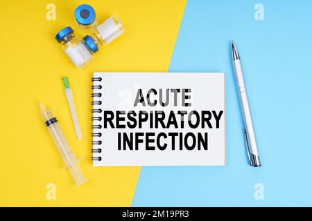 Médecine et concept de santé. Une seringue, des ampoules et un carnet avec l'inscription - INFECTION RESPIRATOIRE AIGUË Banque D'Images