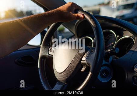 Le conducteur garde les mains sur le volant de la voiture. Banque D'Images