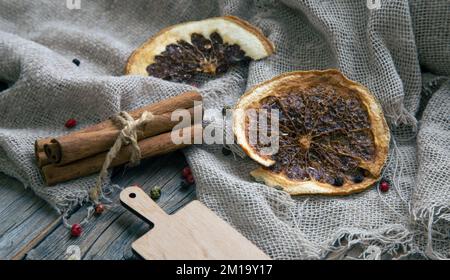 Bâtonnets d'oranges et de cannelle séchés sur toile de jute. Banque D'Images