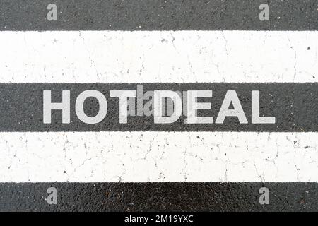 Concept commercial et financier. Sur l'asphalte entre les bandes de séparation blanches l'inscription - HOT DEAL Banque D'Images