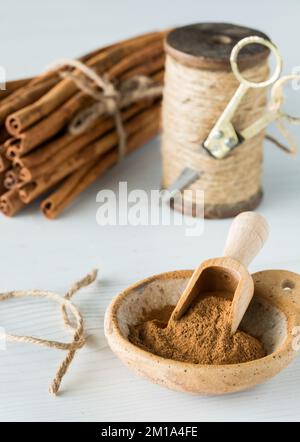 Poudre de cannelle avec un paquet de bâtons de cannelle et une bobine de ficelle derrière. Banque D'Images