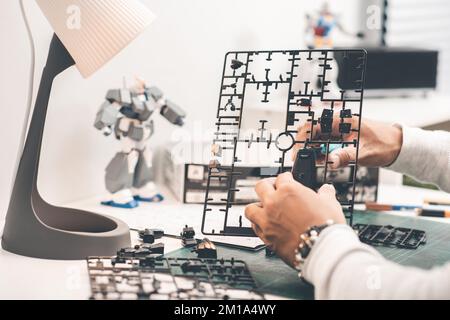 L'homme qui assemble les kits de modèle de robot. Concept loisir et passe-temps. Banque D'Images