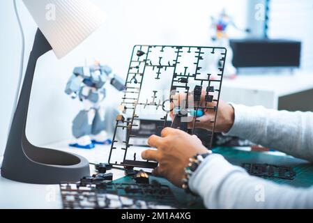 L'homme qui assemble les kits de modèle de robot. Concept loisir et passe-temps. Banque D'Images