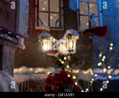 Lanterne de rue vintage, lampadaire extérieur avec lumière jaune dans la neige pendant les vacances d'hiver dans la vieille ville d'Europe. Photo de haute qualité Banque D'Images