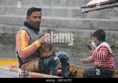 Junaid Ahmad Wani, un coureur de shikara physiquement ablé pagayant son shikara à l'intérieur du lac Dal vierge à Srinagar. Banque D'Images