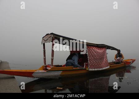 Junaid Ahmad Wani, un coureur de shikara physiquement ablé pagayant son shikara à l'intérieur du lac Dal vierge à Srinagar. Banque D'Images