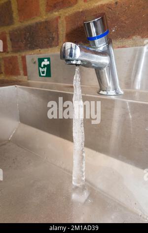 La colonne de glace s'étend d'un égouttement du robinet gelé de sorte que de la glace se forme à partir de l'eau qui coule du robinet. Risque important d'éclatement d'un tuyau en raison du gel par temps froid. (132) Banque D'Images