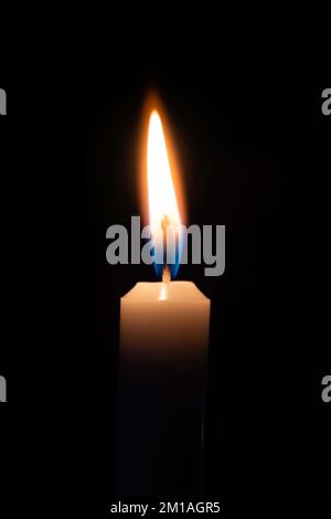 Une chandelle unique brûlante sur un fond noir Uni Banque D'Images