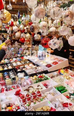 Hanau, Allemagne - 15 décembre 2019: Bulbes suspendus dans un stand vendant des décorations de Noël sur un marché de Noël à Hanau, Allemagne. Banque D'Images