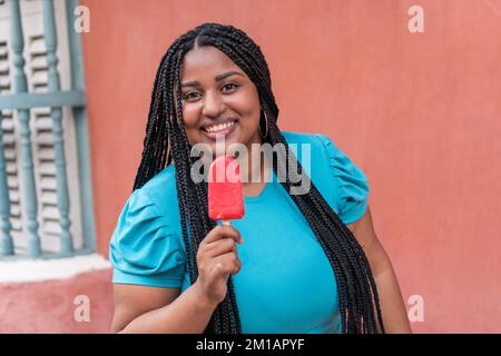 Jeune femme Eating Popsicle sur la rue Banque D'Images
