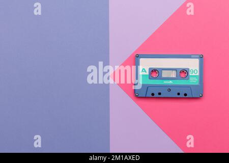 Cassette audio bleue sur fond rose et lilas. Concept de musique audio analogique Banque D'Images