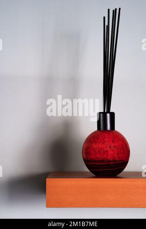 diffuseur reed sur étagère en bois avec ombres sur le mur Banque D'Images