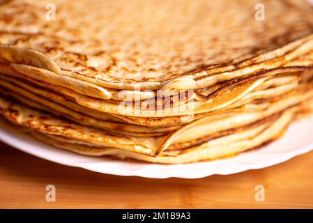 Crêpes sur une assiette blanche. Macro photographie de crêpes. Crêpe macro. Gros plan des crêpes. Petit déjeuner servi en gros plan avec une pile de crêpes. Photo macro Banque D'Images