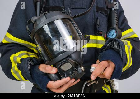 Masque respiratoire de protection complet à la main d'un pompier non reconnu Banque D'Images