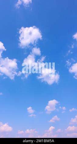 Ciel bleu profond avec nuages - arrière-plan vertical Banque D'Images