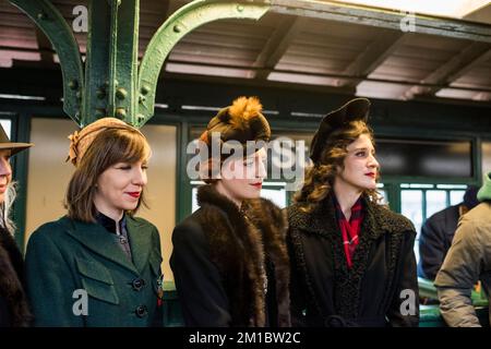 New York, New York - 11 décembre 2022: Personnes dans des vêtements d'époque attendant le train de nombreuses couleurs, vacances nostalgie manèges, NYC Subway Banque D'Images