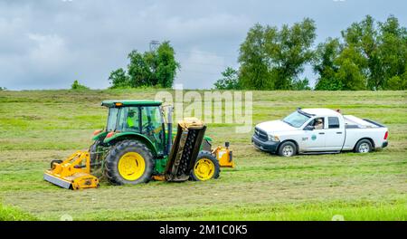 LA NOUVELLE-ORLÉANS, LA, États-Unis - 6 SEPTEMBRE 2022 : tracteur coupant de l'herbe sur le Levee du Mississippi et camion appartenant à l'autorité de protection contre les inondations Banque D'Images