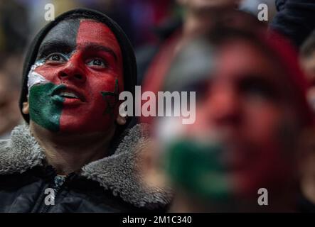 Gaza, Palestine. 10th décembre 2022. De jeunes garçons palestiniens aux visages peints des drapeaux du Maroc et de la Palestine regardent attentivement la diffusion en direct du quart de finale de la coupe du monde de la FIFA entre le Maroc et le Portugal, qui a eu lieu au Qatar, au Saad Sayel Sports Hall de Gaza. (Score final; Maroc 1-0 Portugal) crédit: SOPA Images Limited/Alay Live News Banque D'Images