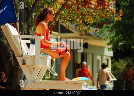 Une jeune femme maître nageur surveille et protège les nageurs à Walden Pond, à Concord, Massachusetts, pour son travail d'été Banque D'Images