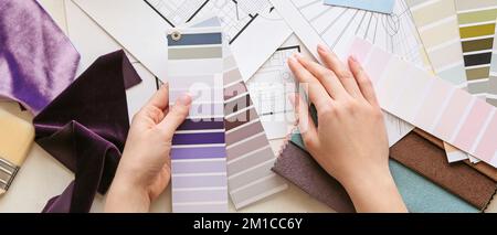 Femme de créateur avec palettes de couleurs de peinture à la table, vue de dessus Banque D'Images