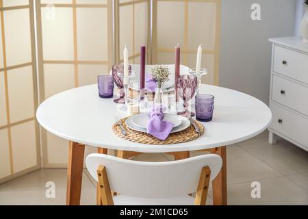 Cadre magnifique, bougies et fleurs de gitsophila sur une table blanche dans une salle lumineuse Banque D'Images