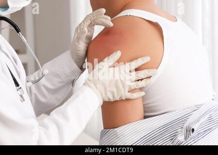 Médecin examinant un homme avec des ecchymoses en clinique Banque D'Images