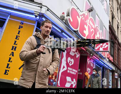 PRODUCTION - 29 novembre 2022, Hessen, Francfort-sur-le-main : le chef de police Niklas Möller, agent de protection sur place, traverse le quartier rouge de la Bahnhofsviertel. Depuis plus d'un an, il est le contact des institutions, des commerçants et des citoyens dans le quartier, un point chaud de la métropole principale. Avec ses tournées, il renforce la sécurité dans le quartier. (À dpa-Korr 'entre le marché hebdomadaire et le brothel - garde de sécurité dans le quartier de la gare') photo: Arne Dedert/dpa Banque D'Images