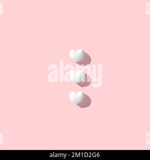 Coeurs blancs sur fond rose. Concept de jour de Saint-Valentin minimal. 3D rendu. Banque D'Images