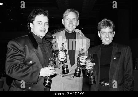 Photo du dossier datée du 7/4/1988 de Matt Aitken, Pete Waterman et Mike stock détenant leur prix Ivor Novello qu'ils ont reçu à la Grosvenor House de Londres. Les producteurs de pop sont sur le point de se réunir pour un documentaire Channel 5, intitulé stock Aitken Waterman: Step Back in Time, avec des entretiens avec Kylie Minogue, Rick Astley, Jason Donovan et Simon Cowell. Le trio a conné beaucoup des succès durables des 1980s et 1990s, et a aidé à lancer la carrière de certaines des plus grandes stars de la musique. Date de publication : lundi 12 décembre 2022. Banque D'Images