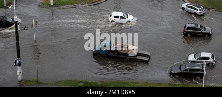 Minsk, Bélarus, août 2022 - des voitures conduisent sur une route inondée de fortes éclaboussures d'eau de pluie. Changement climatique Banque D'Images