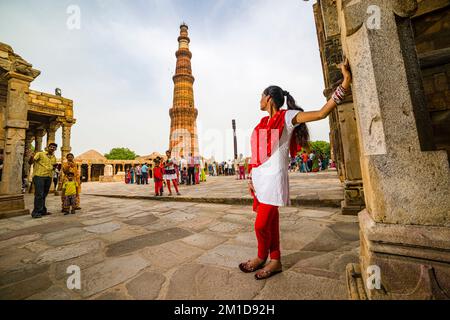 Jeune femme regardant Qutub Minar, également connue sous le nom de Qutb Minar et Qutab Minar, un ancien monument islamique à Delhi Banque D'Images
