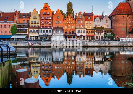 Vieille ville de Gdansk au lever du soleil en Pologne. Vue pittoresque sur la rivière avec maisons en bord de mer et miroir dans l'eau. Banque D'Images
