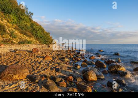 Plage de sable avec rochers sur la mer Baltique au lever du soleil à Gdynia, Pologne. Banque D'Images