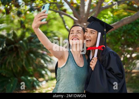 Deux femmes mère et fille diplômé font selfie par smartphone au parc Banque D'Images
