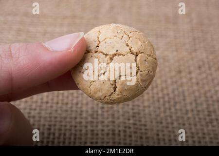 Amande turc cookie dans la main sur une toile de lin Banque D'Images