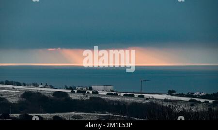 Brighton Royaume-Uni 12th décembre 2022 - le soleil se lève en mer après une chute de neige à Brighton car le temps de gel devrait durer dans les prochains jours dans toute la Grande-Bretagne . : Crédit Simon Dack / Alamy Live News Banque D'Images