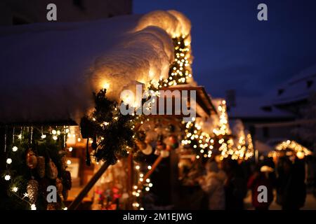 Gros plan d'un marché couvert de neige magnifiquement illuminé et décoré dans un marché de noël à Salzbourg, Autriche. Banque D'Images