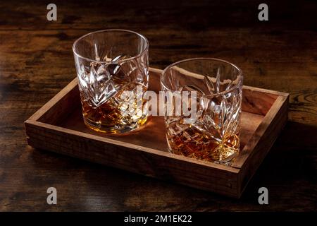 Whisky dans des verres avec glace. Whisky Bourbon sur des rochers sur fond rustique foncé, boissons élégantes, photo moody Banque D'Images