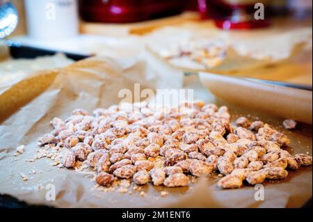 Délicieux amandes grillées faites maison, confites et caramélisées sur du papier de cuisson en saison de Noël. Banque D'Images