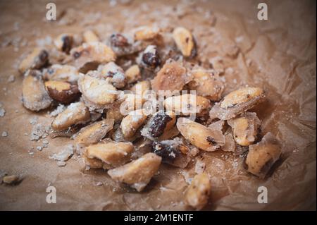 Délicieux pacanes rôties maison, confites et caramélisées sur du papier de cuisson pendant la saison de Noël. Banque D'Images