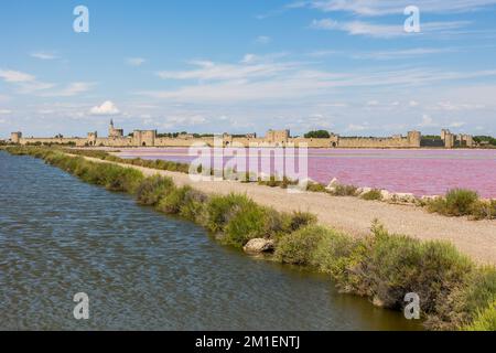 Remparts d'Aigues-mortes devant les marais salants de couleur rose Banque D'Images