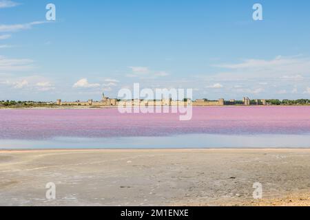 Remparts d'Aigues-mortes devant les marais salants de couleur rose Banque D'Images