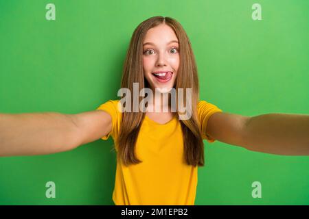 Gros plan selfie de jeune femme souriante et endiablé se fait plaisir de passer du temps avec ses abonnés à diffuser des émissions isolées sur fond vert Banque D'Images